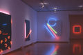 Stephen Antonakos, Installation shot at Bonner Gallery, New York, 1983. Left to right: "Small Cobalt Tube on a Blue Painted Canvas" 1983, 82" x 62". "Neon on Blue Canvas" 1983, 72" x 62". "Distorted Blue Incomplete Circle" 1983, 94"h x 75 1/2"w x 6"d. "Neon Behind a White Surface" 1983, 36"h x 36"w x 6"d